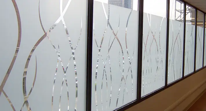 Series of large glass windows with frosted film and decorative clear curved lines, allowing partial light while maintaining privacy.