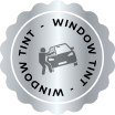 Circular silver badge with a scalloped edge featuring the words "WINDOW TINT" repeated around the border and an icon of a person applying tint to a car window in the center.