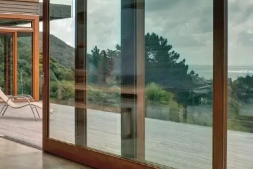Large sliding glass doors with window tint overlooking a scenic landscape