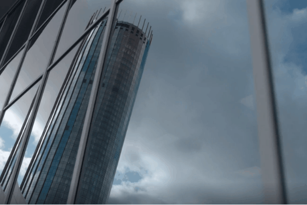Modern high-rise commercial building with reflective glass windows demonstrating solar control window film performance.