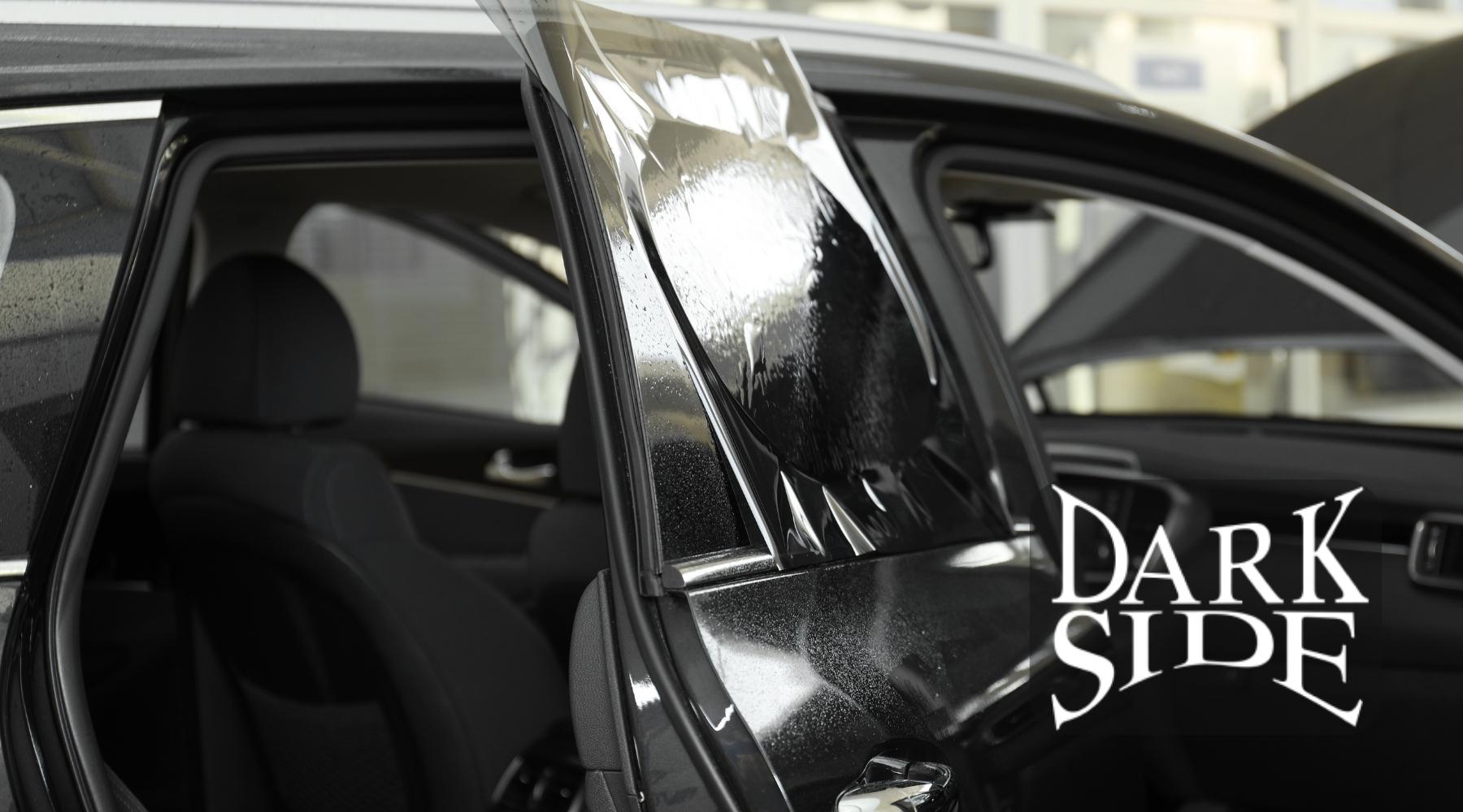 Ceramic window tint film being installed on a car door window by Dark Side Window Tinting