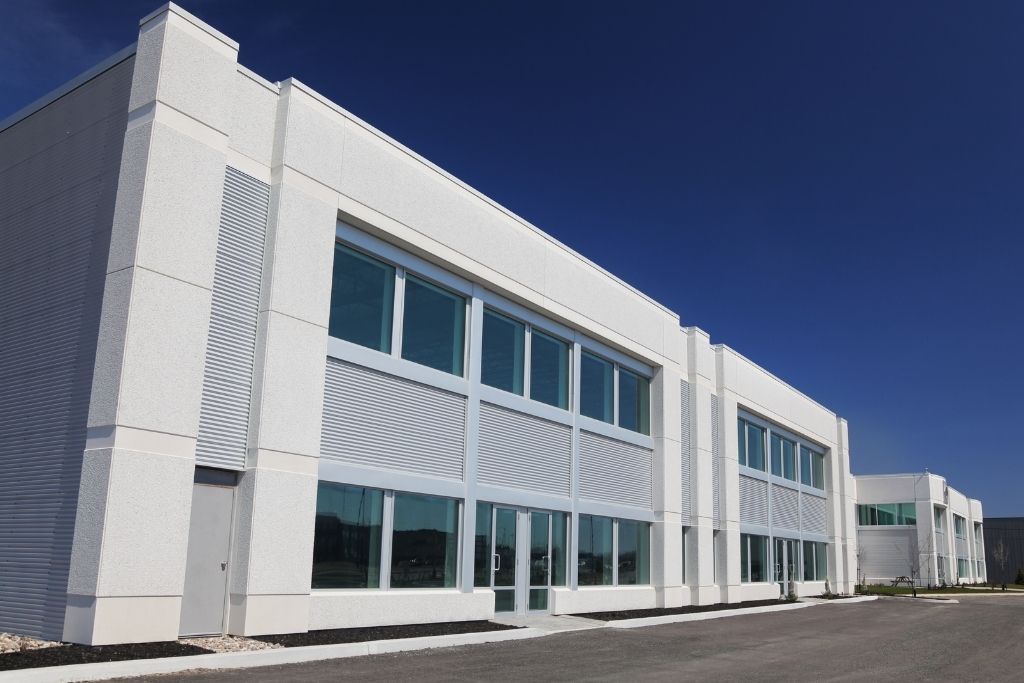 Modern commercial building with large tinted windows beneath a clear blue sky.