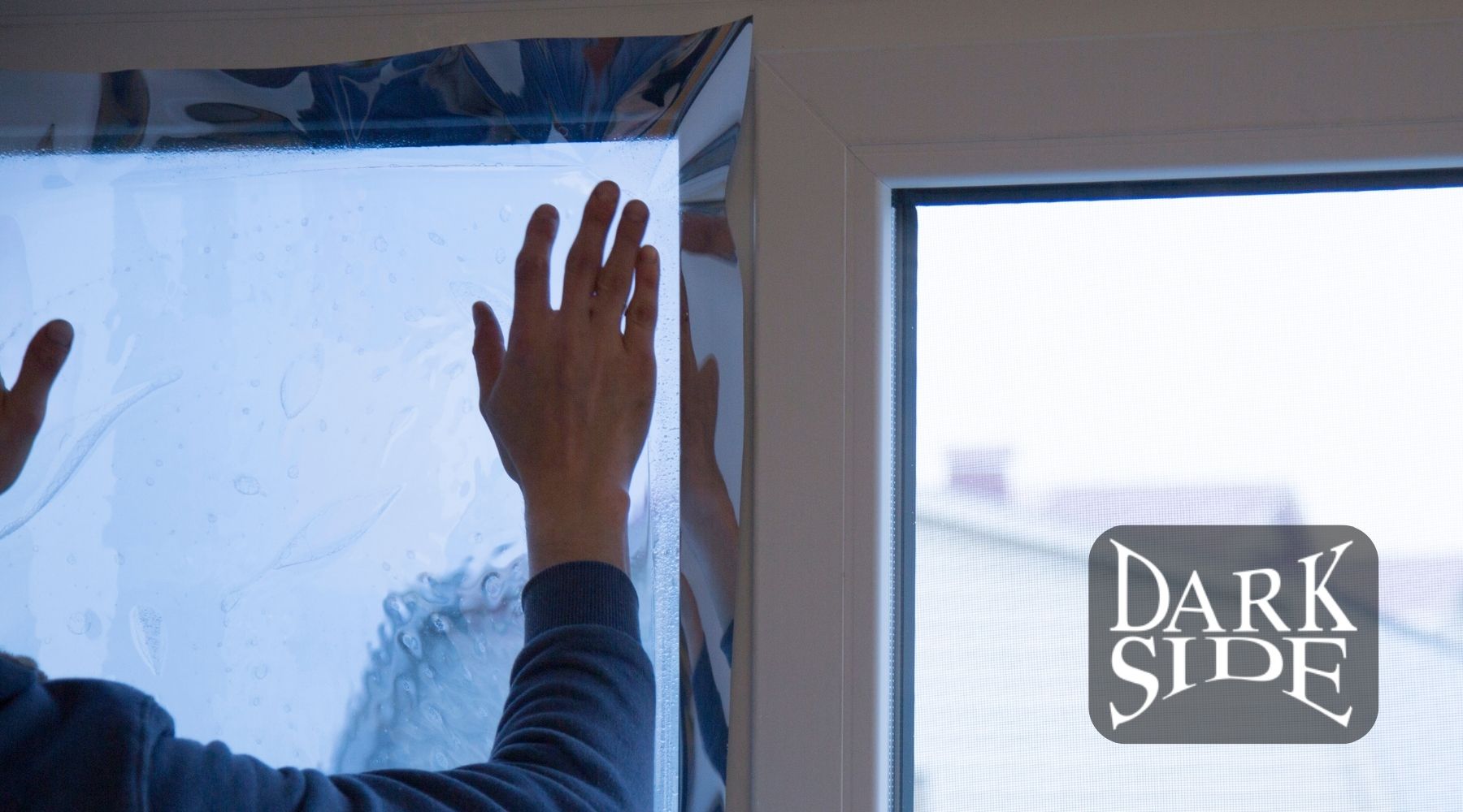 Installer applying architectural window film to a commercial window for Dark Side Window Tinting in Augusta, GA.
