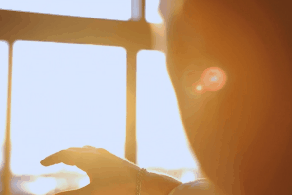 Sunlight shining through an office window onto a computer user, illustrating screen glare and harsh daylight in a workspace.